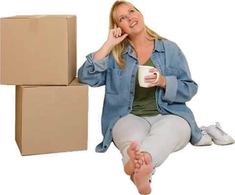 Woman sitting down with boxes next to her, thinking about next step